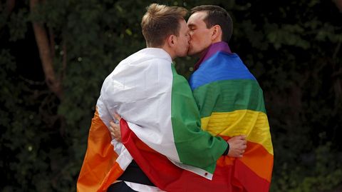 Una pareja se besa mostrando las banderas irlandesa y gay durante una manifestaci�n en Dubl�n