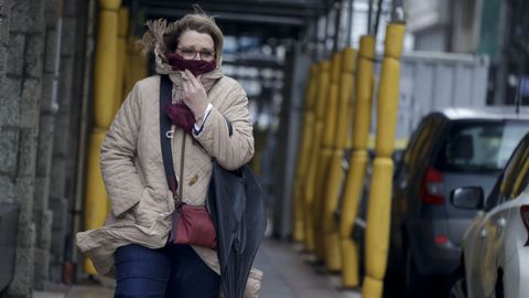 Una mujer con paraguas se protege del viento en A Coru�a