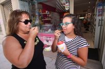 Dos clientas saborean en Boiro unas bolas de helado artesanal con las que refrescan el paladar. 