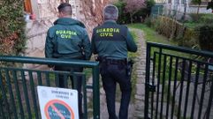 Dos guardias civiles inspeccionan la entrada a la casa de Chantada en la que se registr� el robo