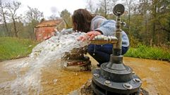 Una vecina de Ponte Caldelas comprueba la temperatura del agua en las fuentes bautizadas como Daniela I y Daniela II. 