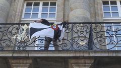 Imagen del momento en el que el concejal del PP Adri�n Villa coloc� una bandera de Ceuta en la balconada del Pazo de Raxoi