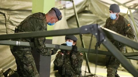 Soldados del regimiento de infanter�a n�mero 3 de la Brigada Galicia con base en Cabo Noval durante el repliegue parcial de la estaci�n de triaje instalada por el ej�rcito en uno de los aparcamientos del Hospital Universitario Central de Asturias (HUCA)