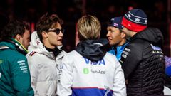 Fernando Alonso y Liam Lawson.Fernando Alonso y Liam Lawson conversan con otros pilotos