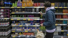 Un joven observa bebidas energticas de distintas marcas en un supermercado