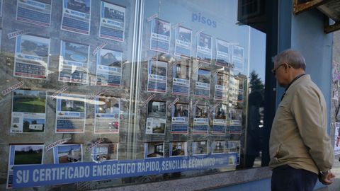 Un cliente observa ofertas de pisos en una inmobiliaria