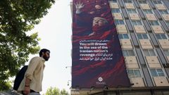 Un hombre pasa ante un mural en Teher�n que reclama venganza para los presidentes de Estados Unidos e Israel