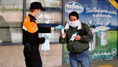 Miembros de Protecci�n Civil de Oviedo reparten mascarillas este martes en la estaci�n de autobuses de Oviedo