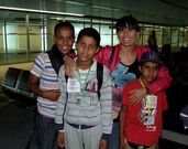 Tres de los ni�os saharauis, a su llegada al aeropuerto de Lavacolla, con Sara Cebreiro detr�s.