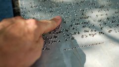 Una persona leyendo en Braille una se�al de informaci�n