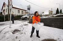 Una voluntaria de Protecci�n Civil, vertiendo escamas de deshielo al lado del colegio O Cruce.