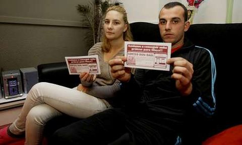 Estefan�a y Pedro, los padres de la ni�a, en su casa de Fazouro con las rifas que tienen a la venta.
