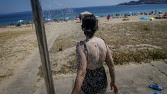 Una bañista utilizando una ducha en la playa de Coroso, en Ribeira.