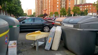 Colchones tirados en una isla de contenedores en un barrio de Gijn