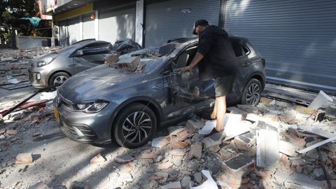 Un hombre observa un veh�culo afectado tras un fuerte temblor este lunes, en Cali (Colombia).