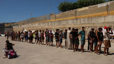 Un grupo de migrantes hace cola para recibir ayuda de la oeneg� Media Luna Blanca en Ceuta.