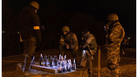 Soldados del Ej�rcito ucraniano, al que Oleksandr hace donativos, juegan a las damas con c�cteles molotov al este de Kiev.