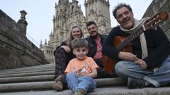 Izan, con sus padres, Antonella y Nacho, y el m�sico Tato L�pez en las escaleras del Obradoiro