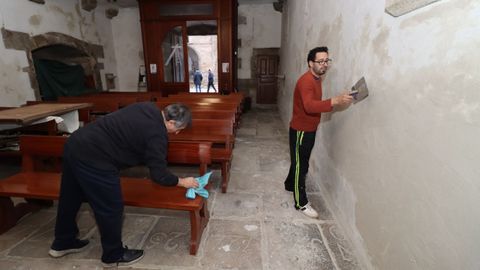 Miembros de la Irmandade do Cristo da Misericordia reparan las paredes laterales de la iglesia de Boiro