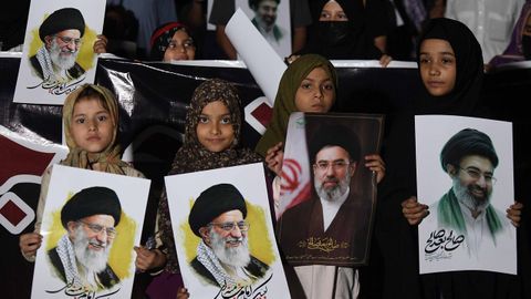 Un grupo de ni�as pakistan�es sostienen fotos de Al� Jamen�i y de su hijo Mojtaba, nuevo l�der supremo