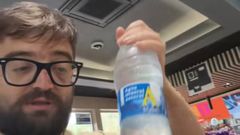 Cocituber con una botella de agua en una gasolinera de Asturias
