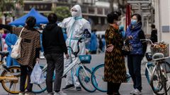 Un oficial de polic�a distribuye a la gente en la zona confinada de Shangh�i, al este del r�o Huangpu