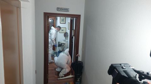 Dos agentes del rea de Criminalstica de la Guardia Civil inspeccionan y recaban datos en el piso asaltado en Carballo.