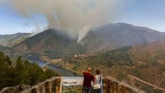 Una pareja contempla el incendio de A Pobra desde el mirador de Torbeo