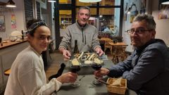 Adolfo, en el centro, sirve una tabla de quesos a unos clientes en la vinoteca Cotrozo