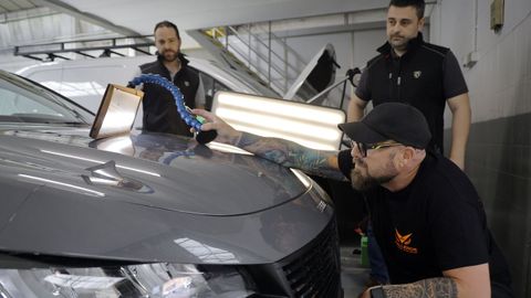 �scar Mart�nez, varillero de Madrid, ya estaba en Galicia horas antes de caer la granizada. En la imagen, repara la chapa de un coche en el concesionario Dimolk de Perillo, junto a los mec�nicos Fernando Vigo e Iv�n Lema.
