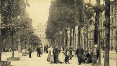 Una de las primeras im�genes del paseo de los �lamos, hacia 1910, donde se aprecian los grandes ejemplares y se atisba a la derecha el antiguo pasaje de Ur�a. Ese arco ha desparecido. Al fondo se ve tambi�n el palacete de la esquina de Ur�a con Torenta, igualmente derribado