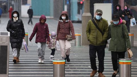 Una pareja atraviesa el paso de peatones en una calle de Beijing