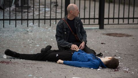 Un padre agarra la mano de su hijo, un ni�o de 13 a�os que muri� en un ataque ruso en la ciudad de Jarkov