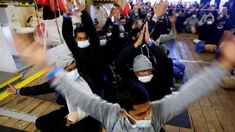 Un grupo de migrantes a bordo de un barco de Médicos sin Fronteras, a punto de desembarcar en el puerto italiano de Bari