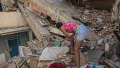 Una mujer entre las ruinas de edificios derrumbados en La Guaira.