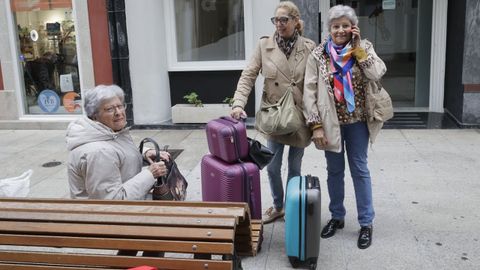 tasa.Tres turistas debatan este lunes sobre la tasa turstica junto a sus maletas, en A Corua.