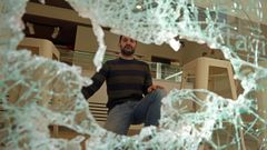 Enrique Casta�o, gerente de la confiter�a Dominga muestra los da�os en el escaparate de su tienda de Ribeira