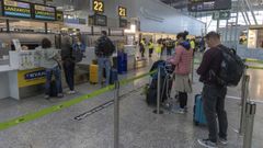 Viajeros, ante uno de los mostradores de facturaci�n del aeropuerto de Santiago, en foto de archivo