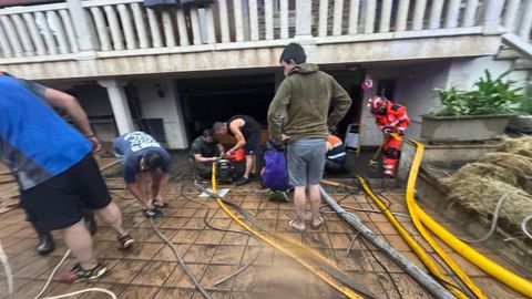Vecinos y equipos de emergencias trabajando en Vilamart�n de Valdeorras tras la fuerte tormenta.