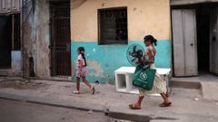 Una mujer camina con su hija por las calles de La Habana.