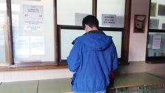 Un alumno con mascarilla esperan a ser antendido en la secretar�a del instituto Jovellanos, de Gij�n 