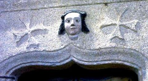 El dintel de la puerta tiene labrado una faz policromada y dos cruces sanjuanistas. 