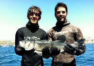 Pedro y C�sar con la enorme lubina que pescaron en Malpica.