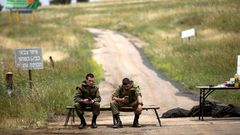 Dos soldados del Ej�rcito de Israel observan sus tel�fonos m�viles cerca de la frontera de Israel con Siria