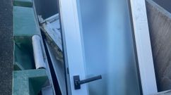 Ventanas depositadas en un contenedor de la basura