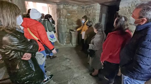 Un grupo de visitantes observa el ara romana localizada en el almacn del convento de Santa Clara 