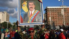 Un hombre uniformado muestra un retrato de Maduro durante unos ejercicios militares en Caracas