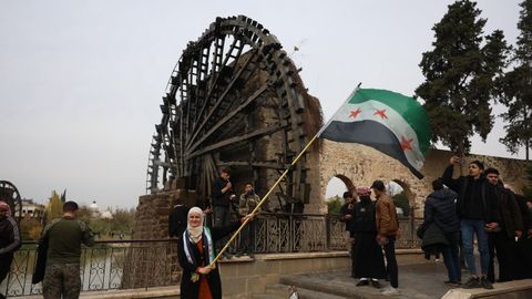 Una mujer ondea una bandera siria en Hama 