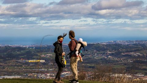Una pareja con un ni�o y Gij�n de fondo