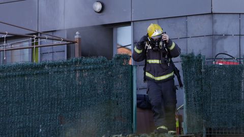 Bombero saliendo del bajo que ardi� en un edificio de la calle Eduardo Blanco Amor